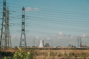 Aukštos įtampos elektros perdavimo linijos, elektros perdavimo bokštai ir pramonės kompleksas horizonte